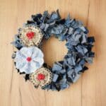 old blue jeans rag wreath hanging on wood wall