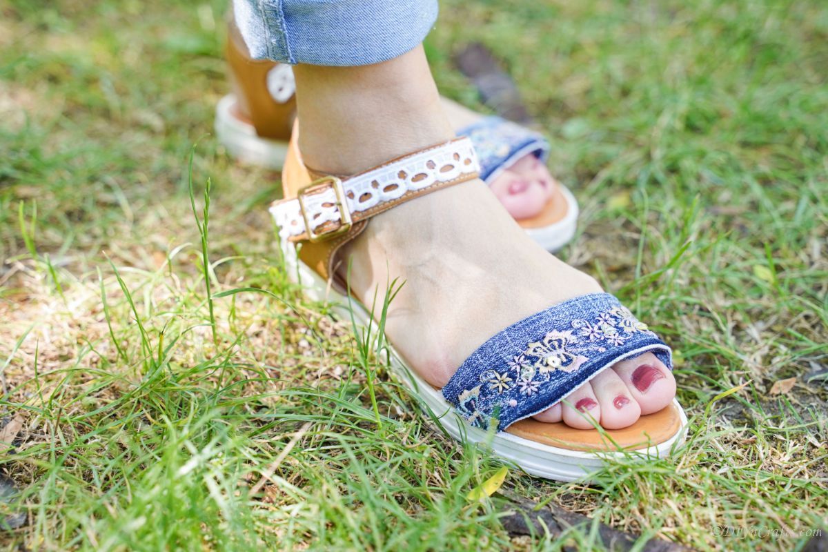 woman in blue jeans wearing denim sandals on grass