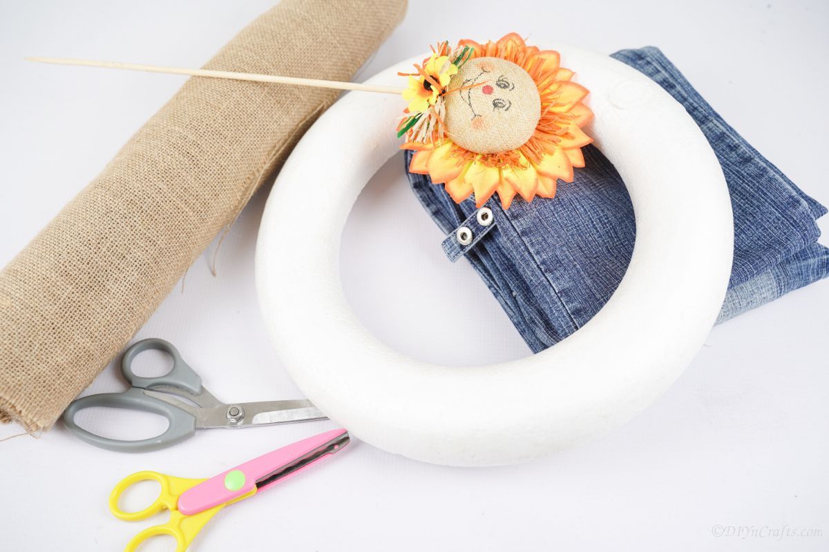 white foam wreath form on table with denim and scarecrow decoration