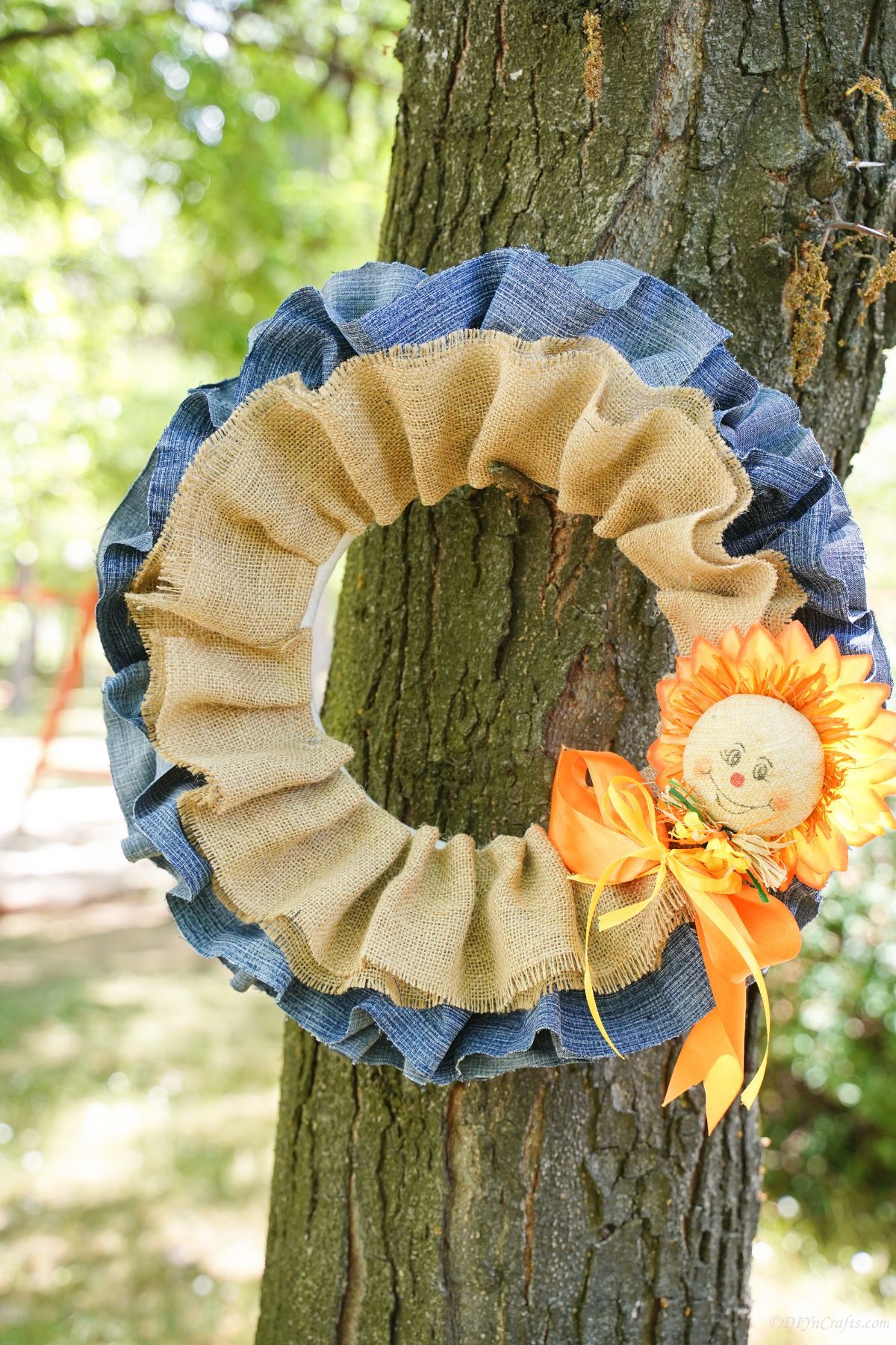 fall burlap and denim wreath with scarecrow on tree