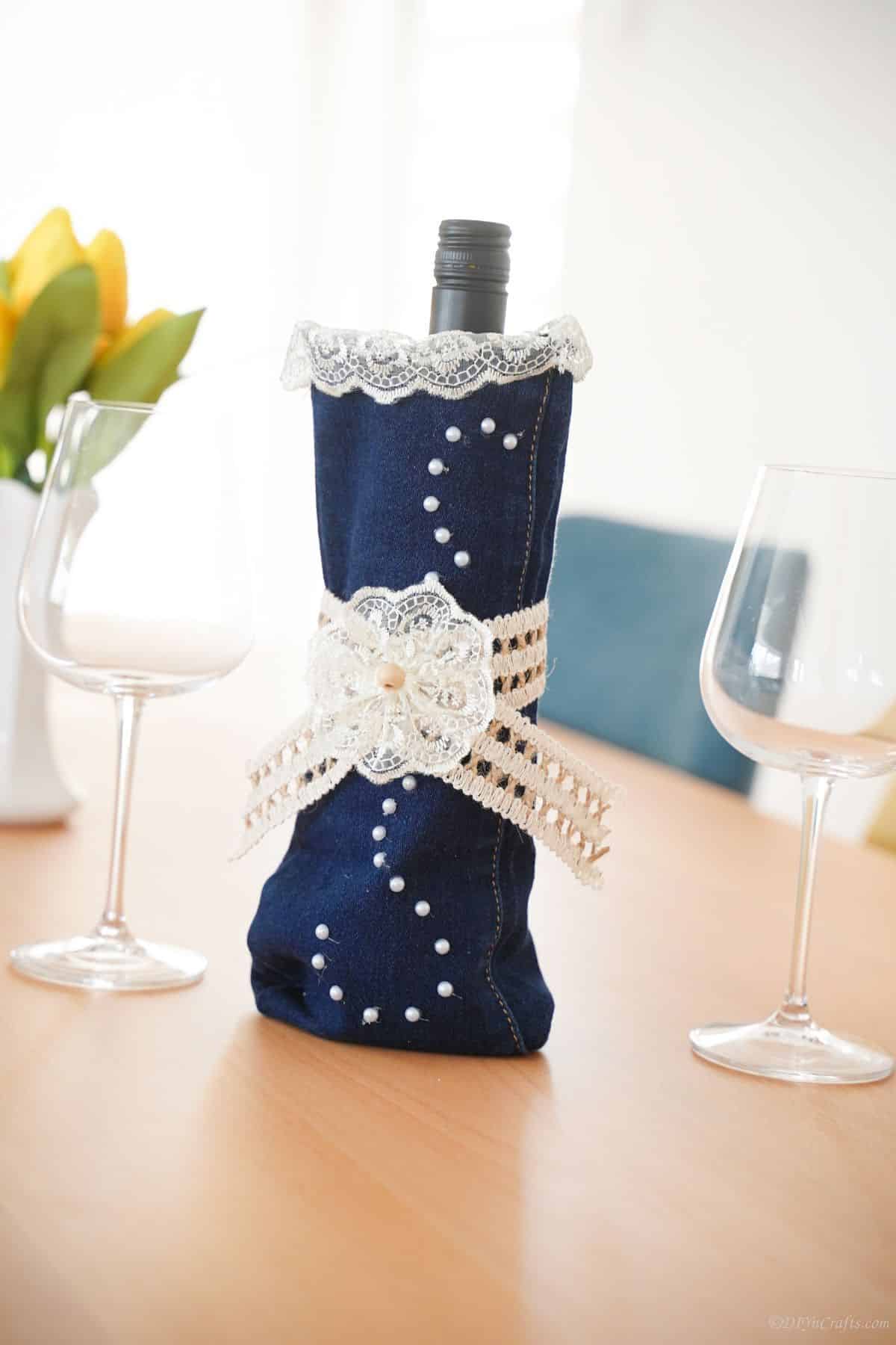 wine bottle cover with lace around middle and beads on sides