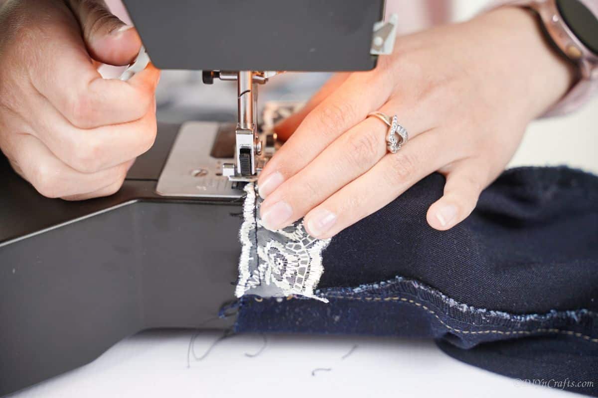 lace being sewn onto denim with sewing machine