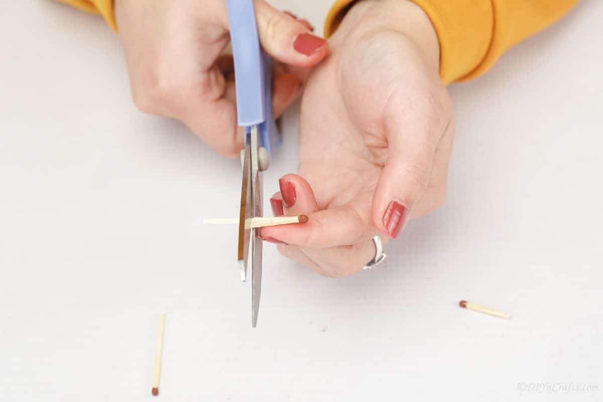 blue scissors being used to cut matches