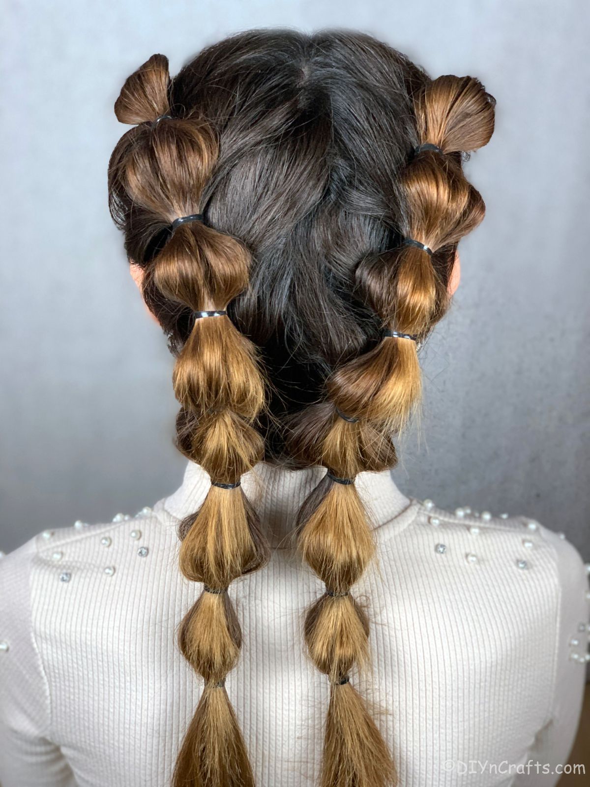 close up image of bubble braids on brunette