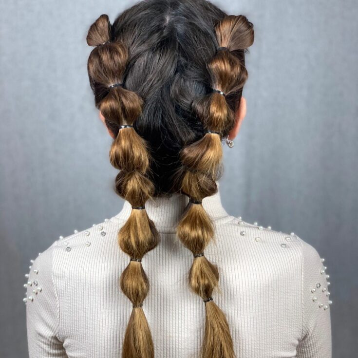 two bubble braids on back of brunettes in white shirts head