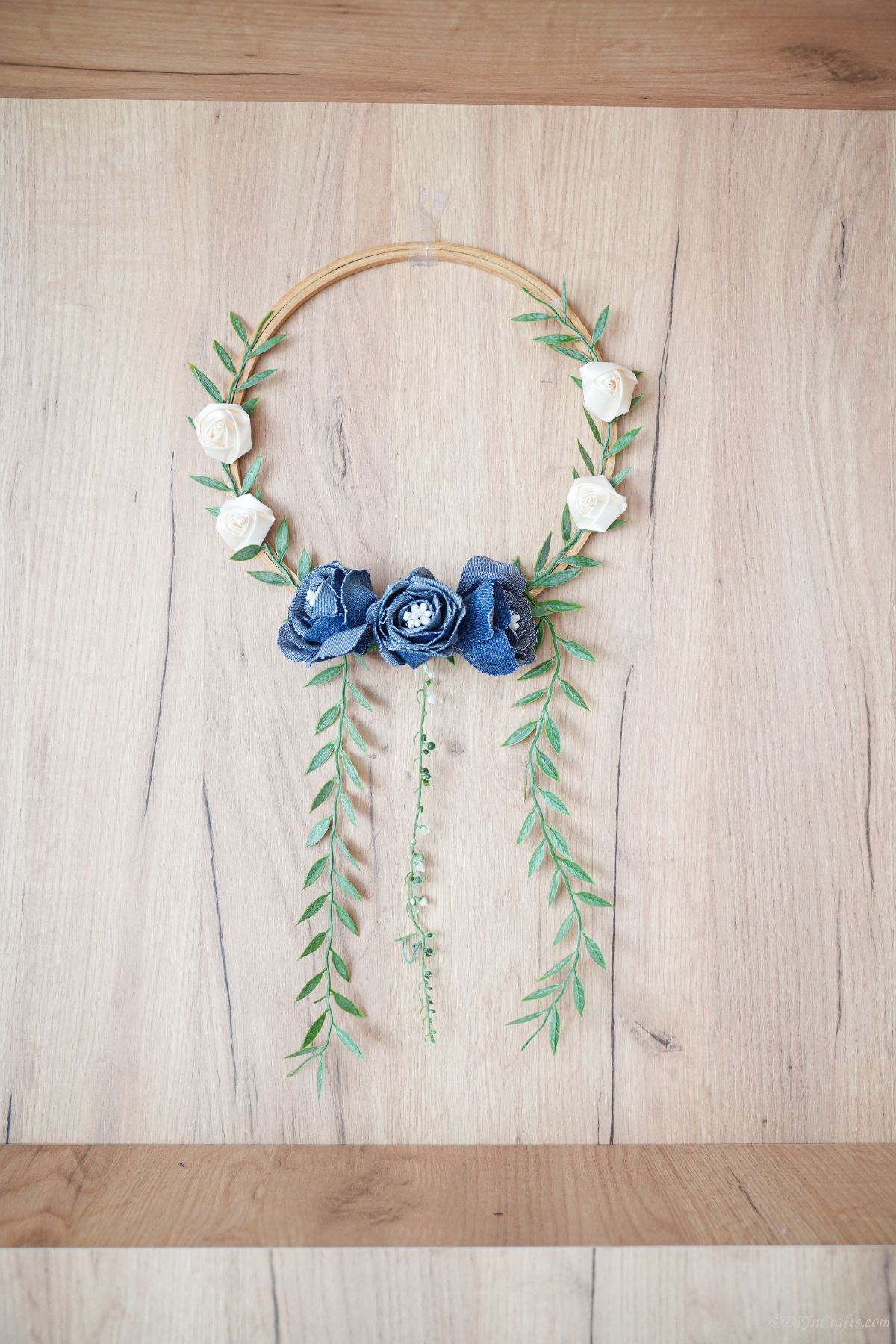 denim floral wreath hanging on wood wall