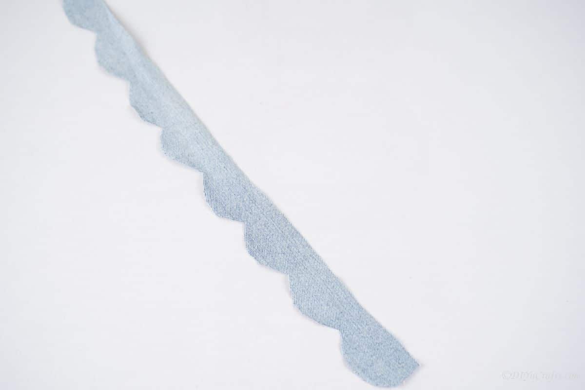 scalloped ribbon of denim on white table