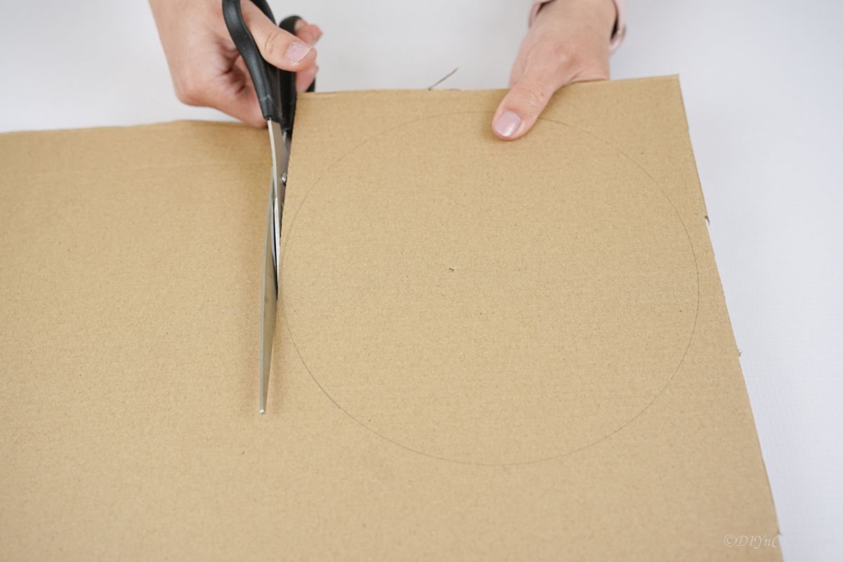 black scissors cutting cardboard circle