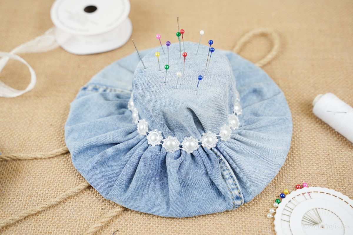 close up image of denim hat with pins in top