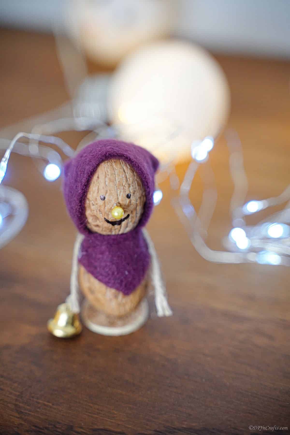purple bonnet and scarf on fairy garden mouse sitting on wood table