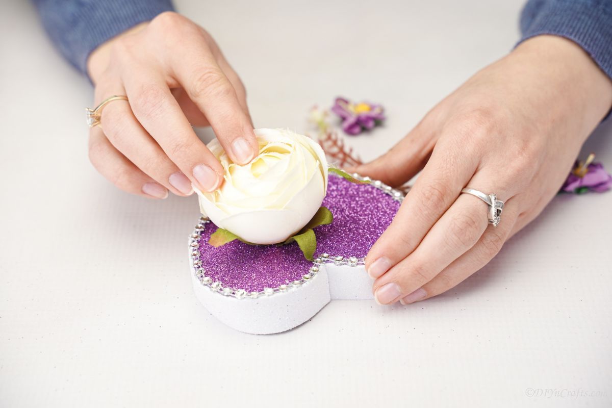 gluing white flower on top of purple heart lid