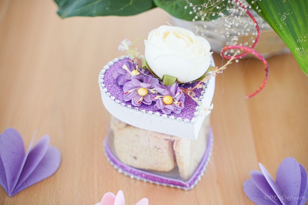 white and purple heart box on a wooden table