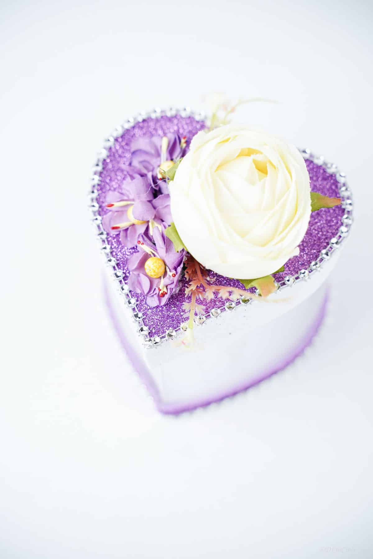 white background behind heart box with purple lid