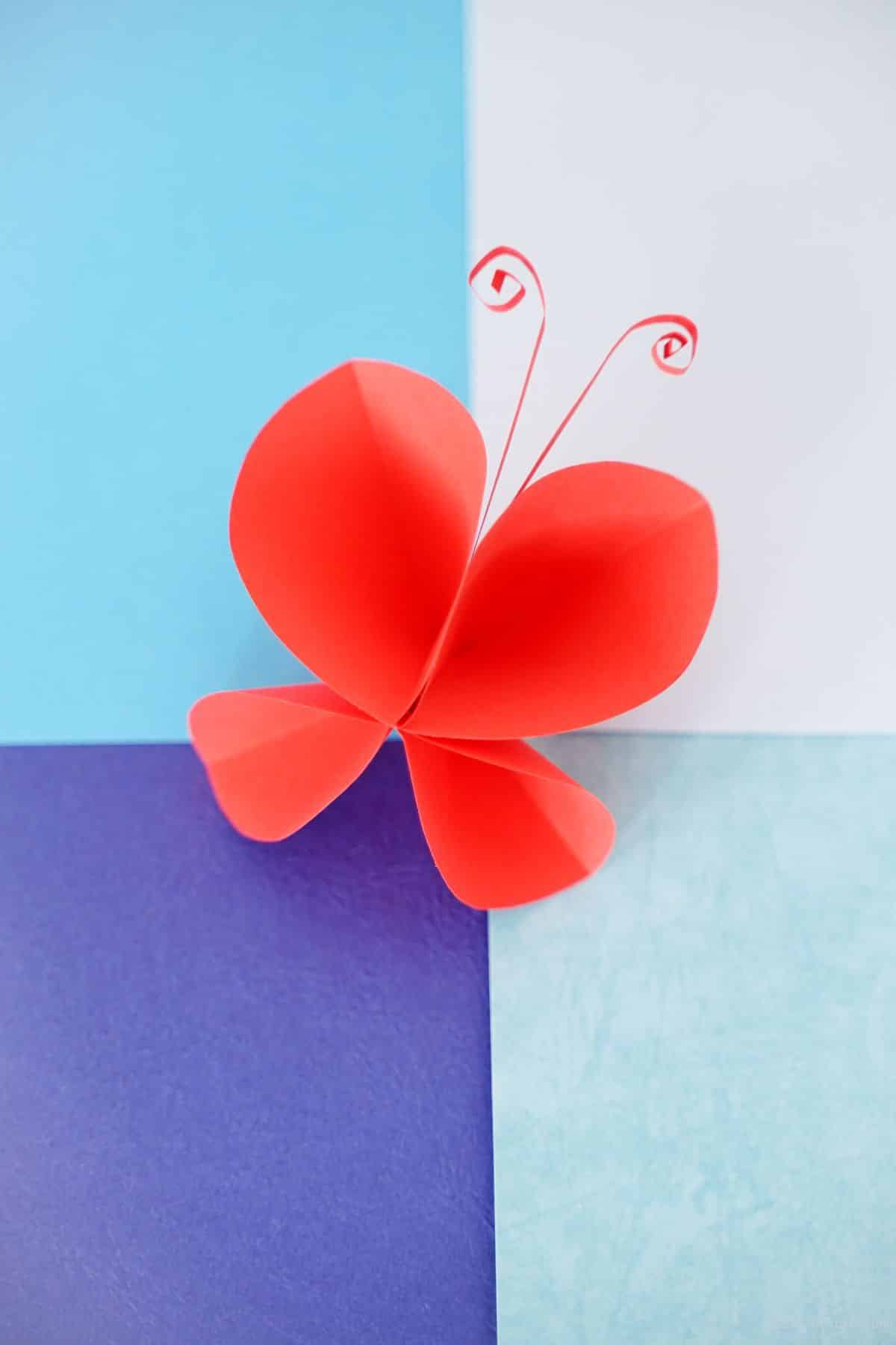 red paper butterfly on blue paper