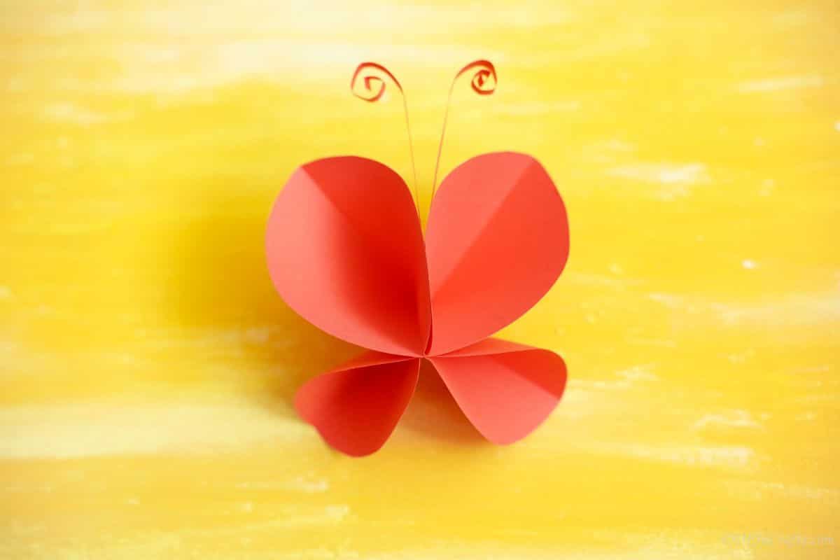 red paper butterfly on yellow surface