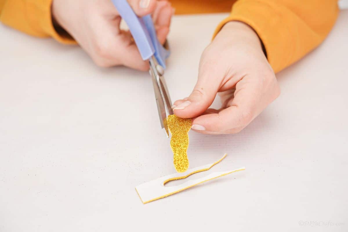 blue scissors cutting gold paper