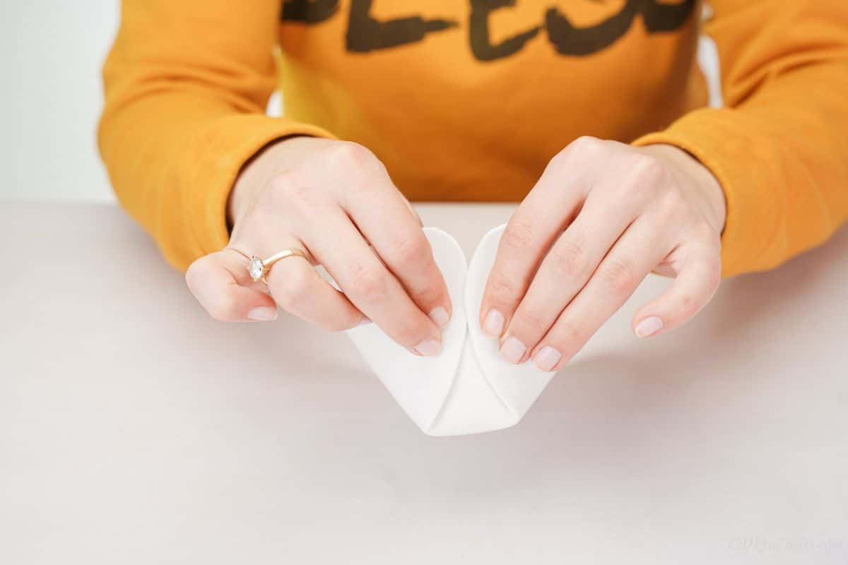 hands folding white paper into box