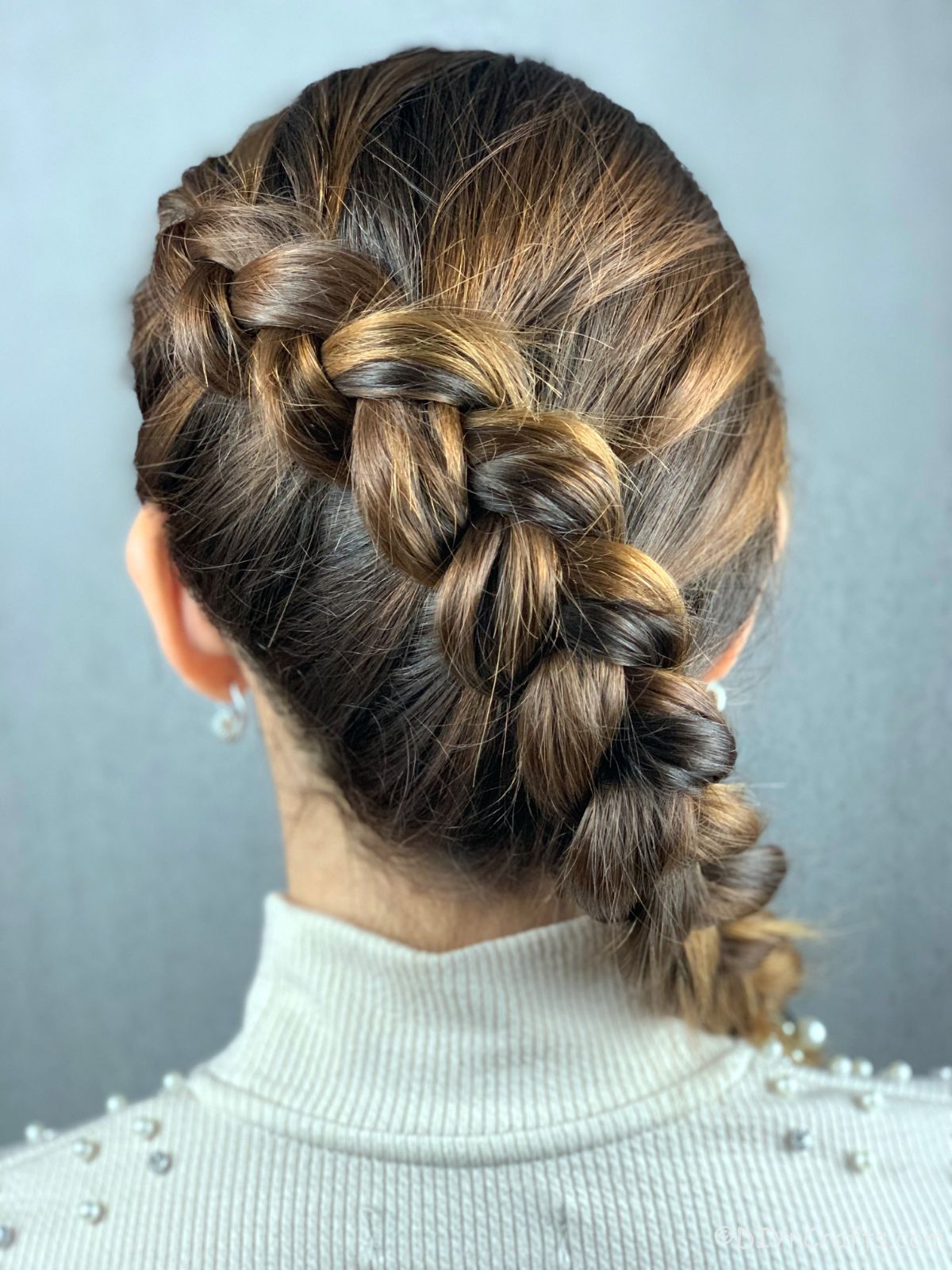 back of side Dutch braid hanging over shoulder of woman in white