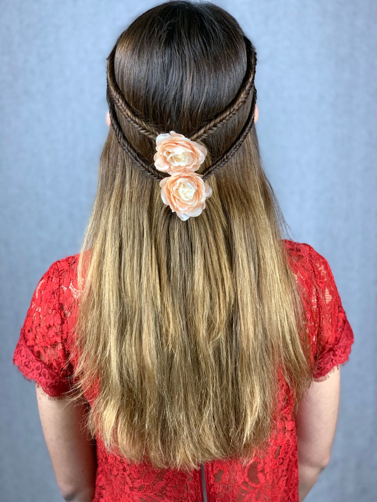 braided hair half up with coral flower clips on back of head