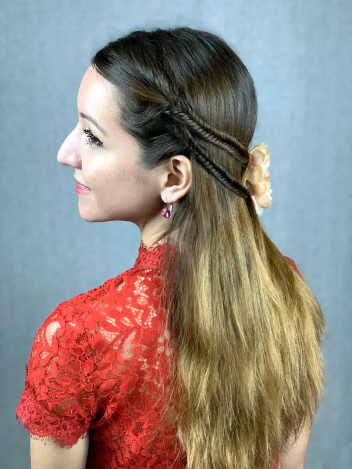 side of braided half up hairstyle on brunette in red shirt