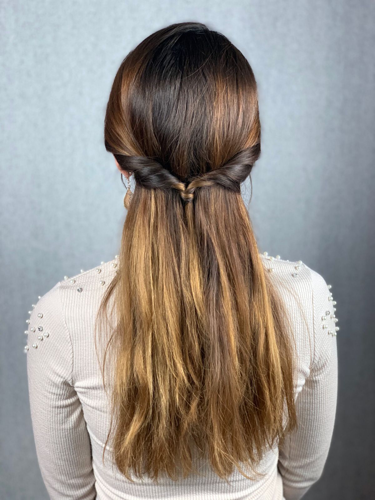 back of twisted half up hairstyle on brunette woman