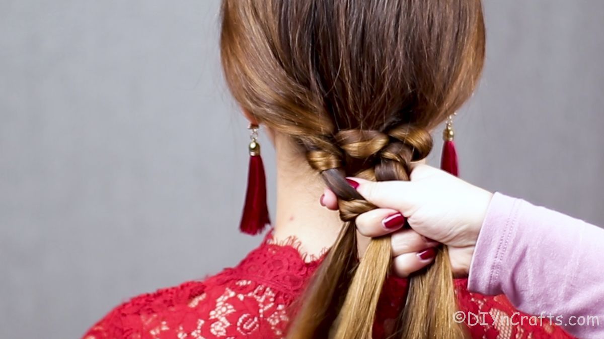 lady holding hair behind head in braid