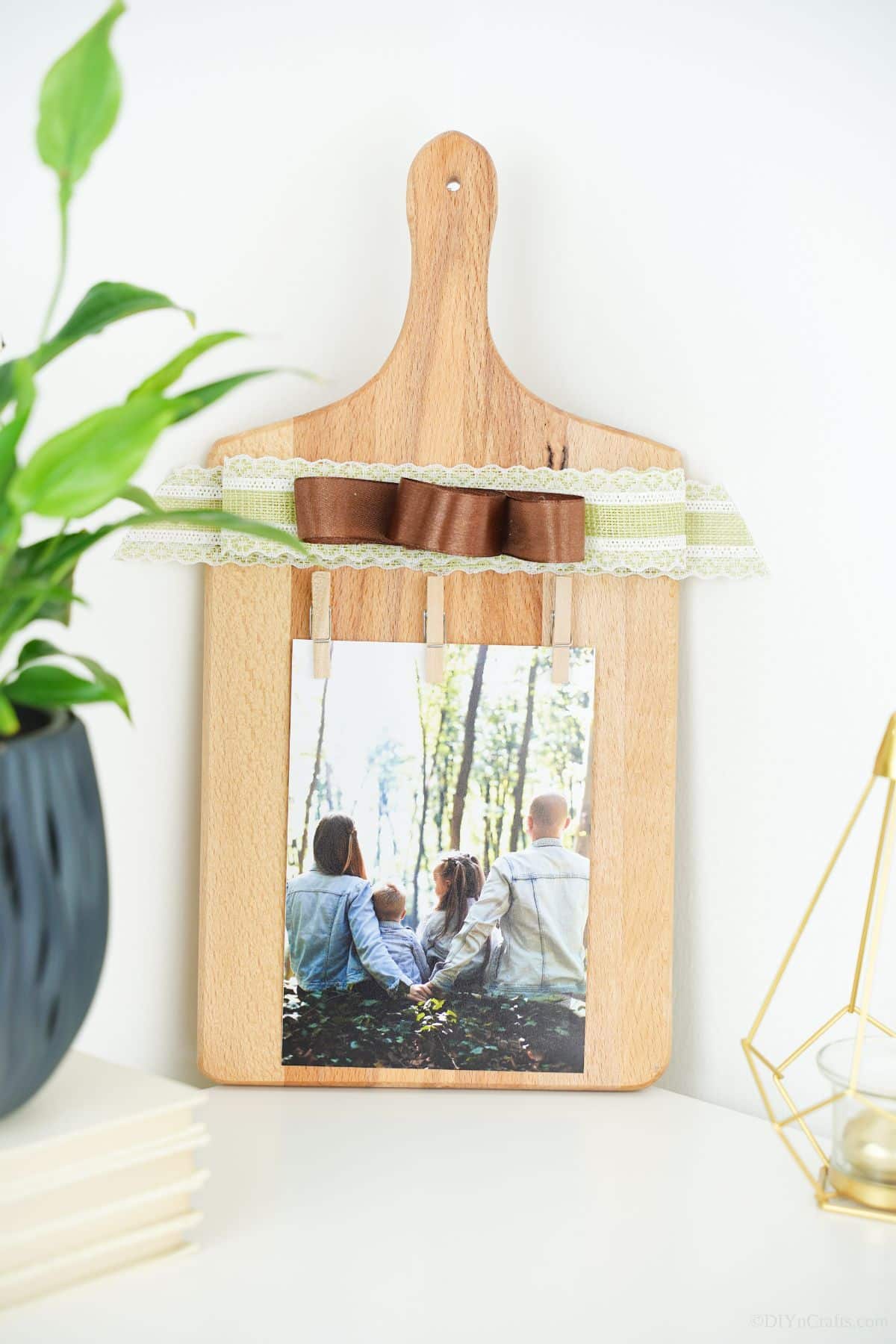 photo board made of cutting board on table by blue potted plant