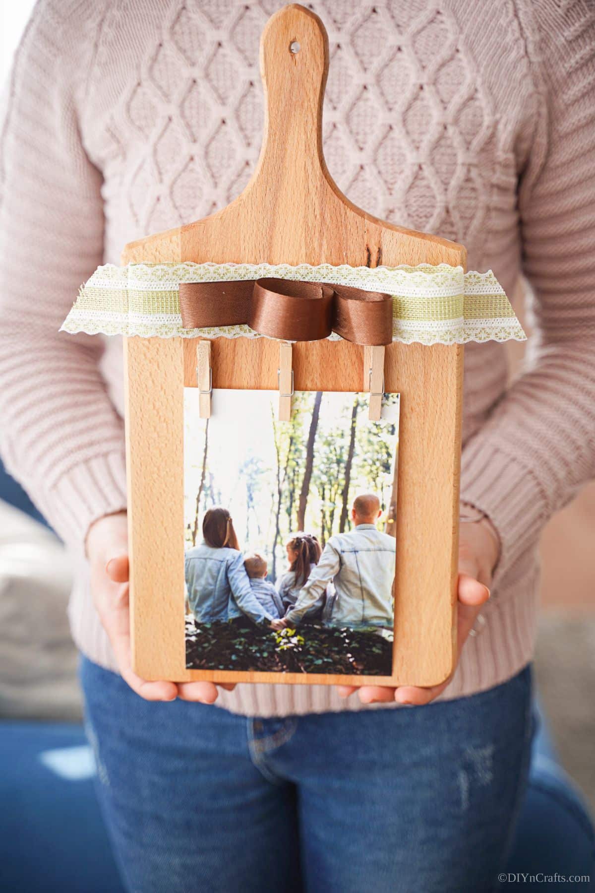 cutting board photo stand being held by woman in pink shirt