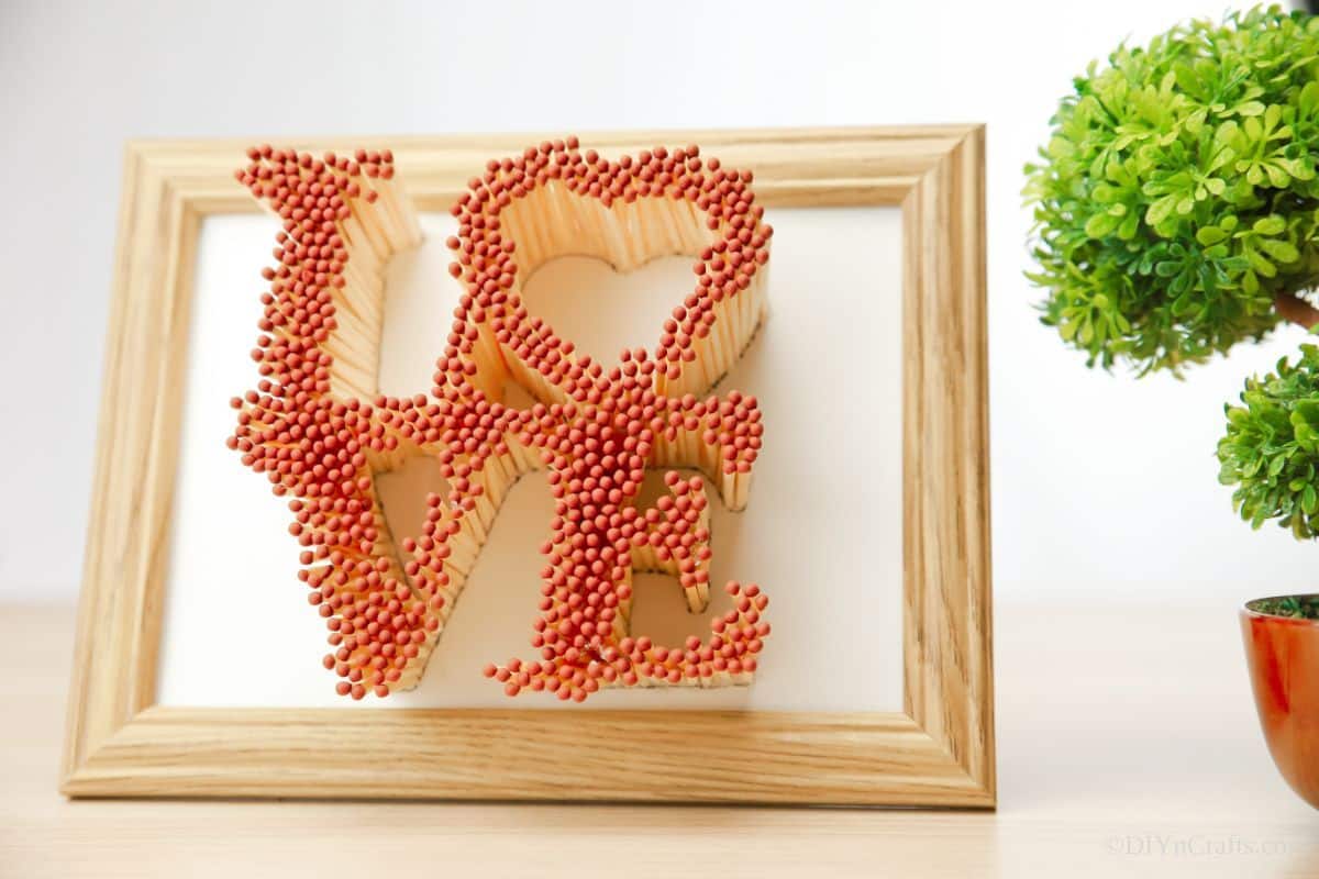 wood picture frame with love sign made of matches