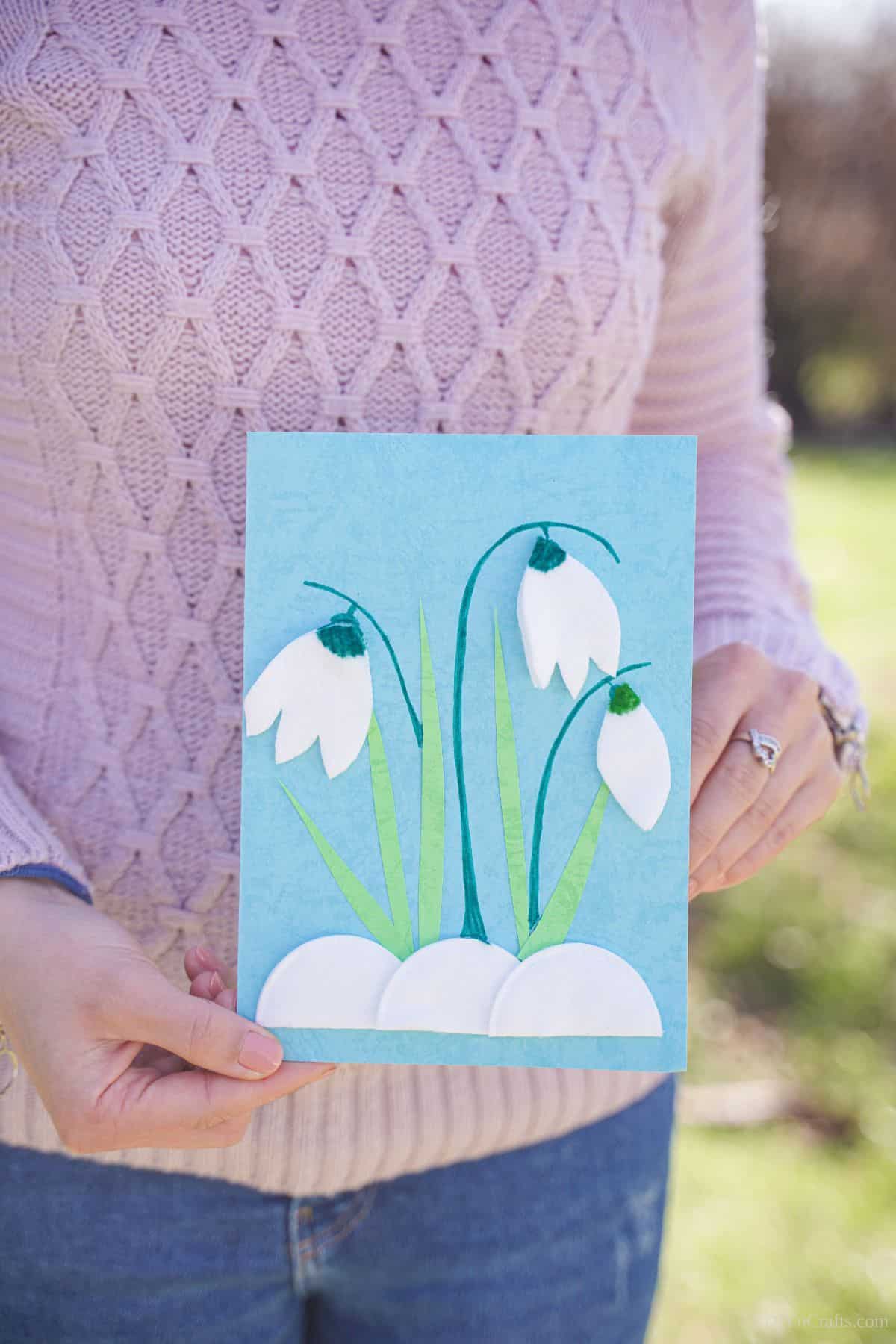 woman in pink holding blue card with tulips on front