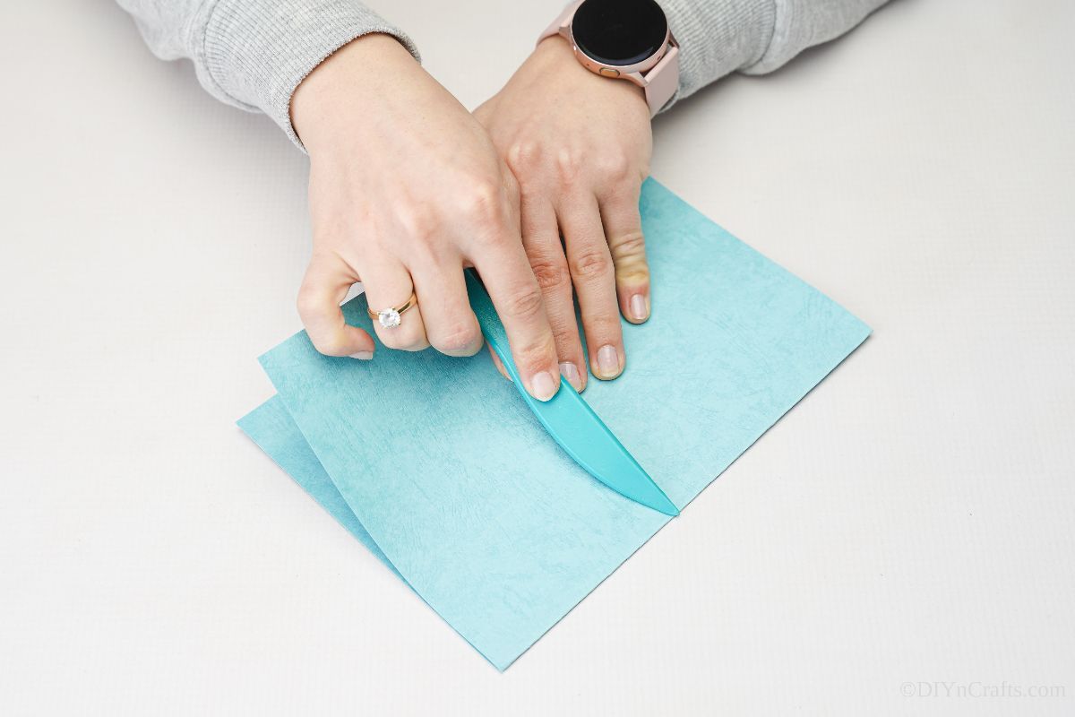 hand folding blue paper
