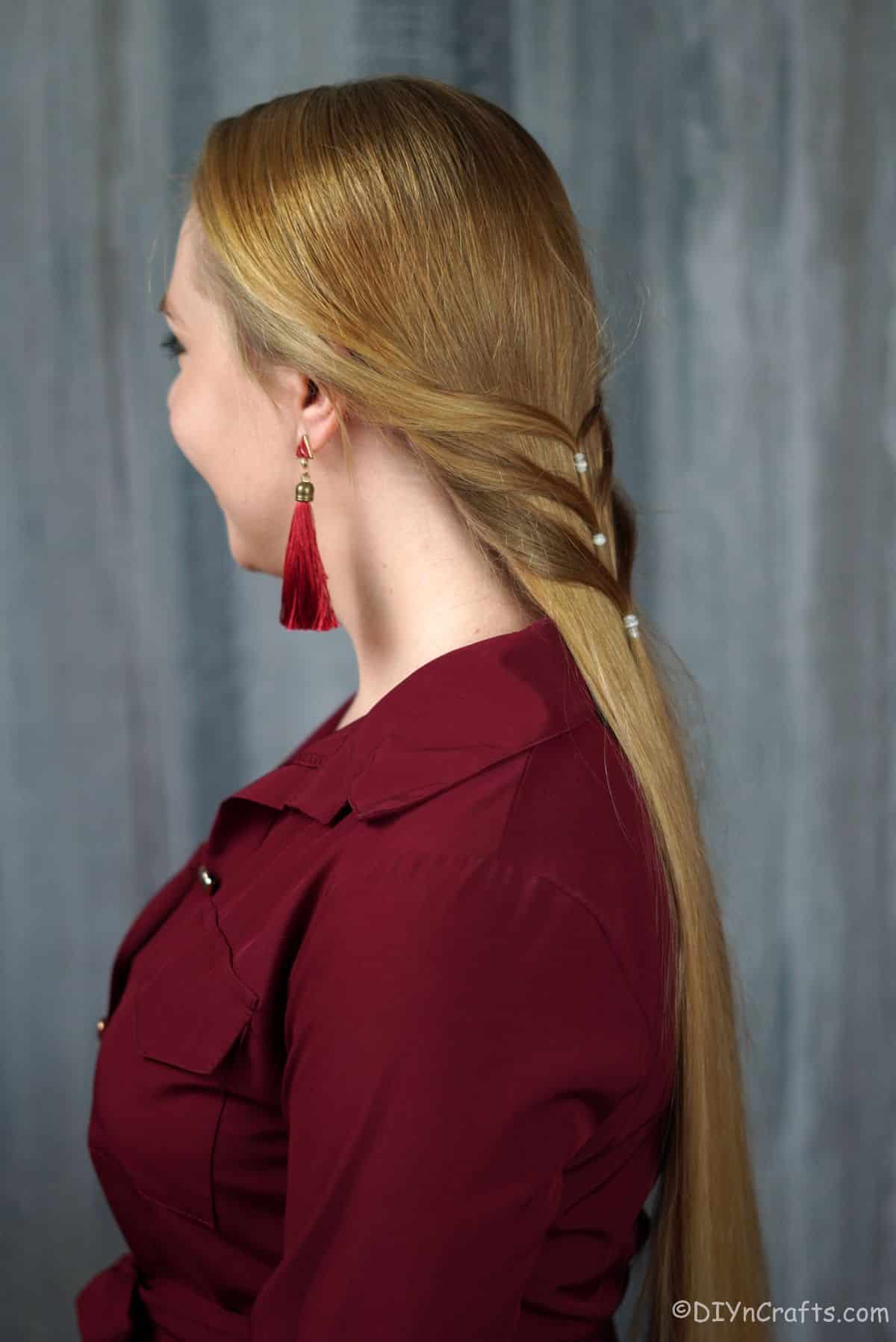 blonde woman in red shirt with low ponytail