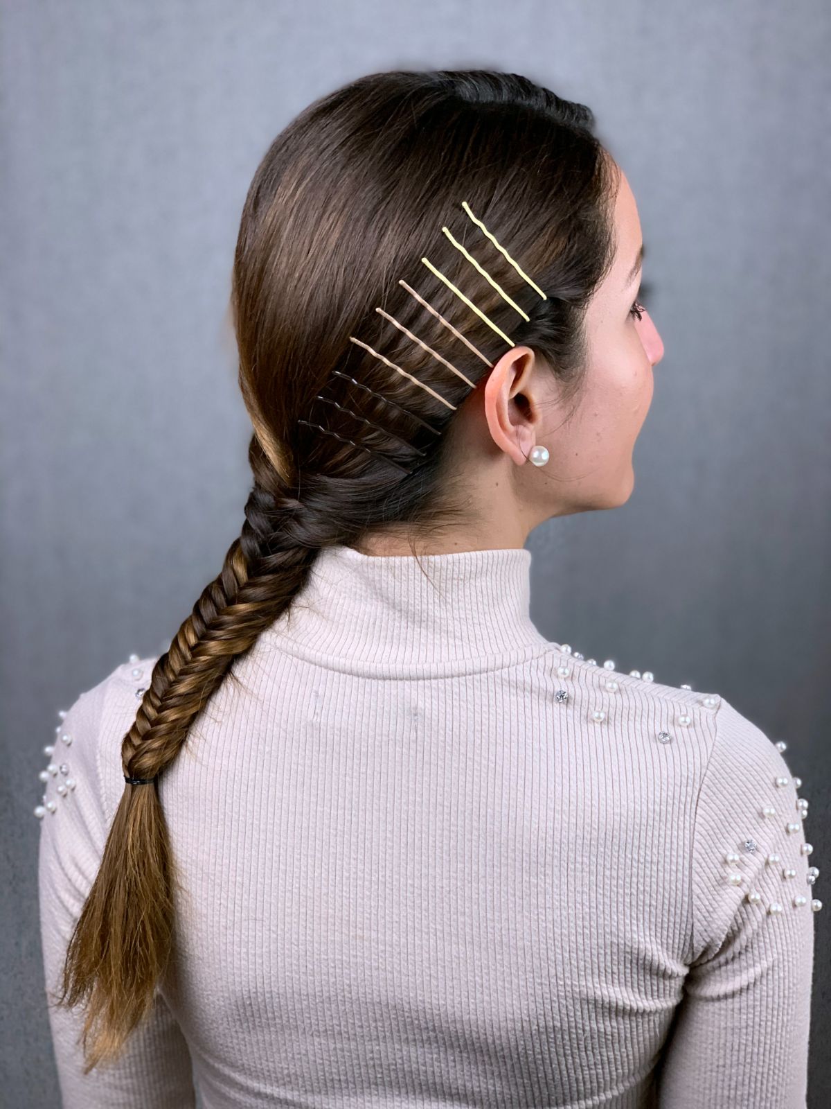 lady with brown hair and fishtail braid over back of pink sweater