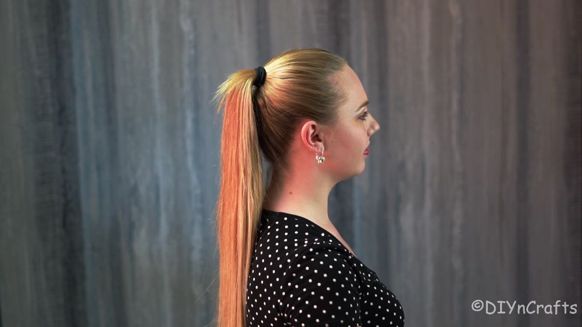 blonde girl in black and white shirt with high ponytail