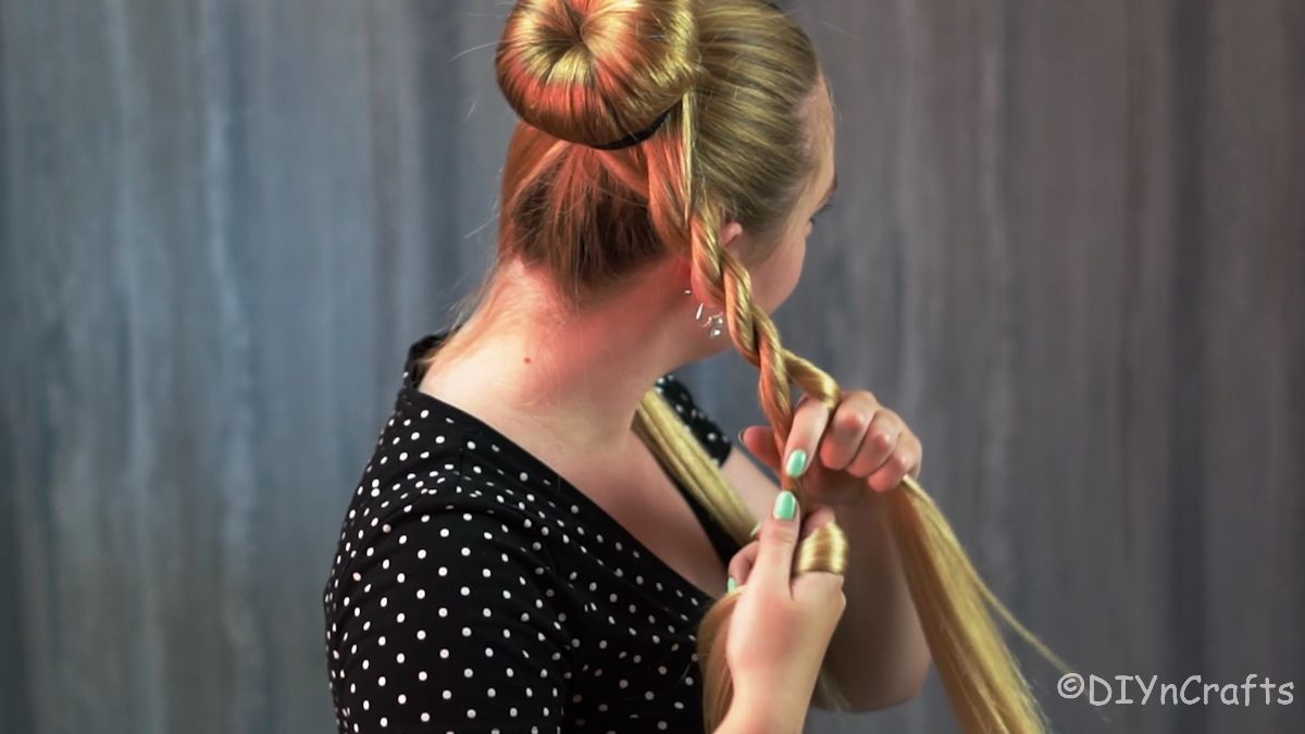 blonde girl with bun twisting hair