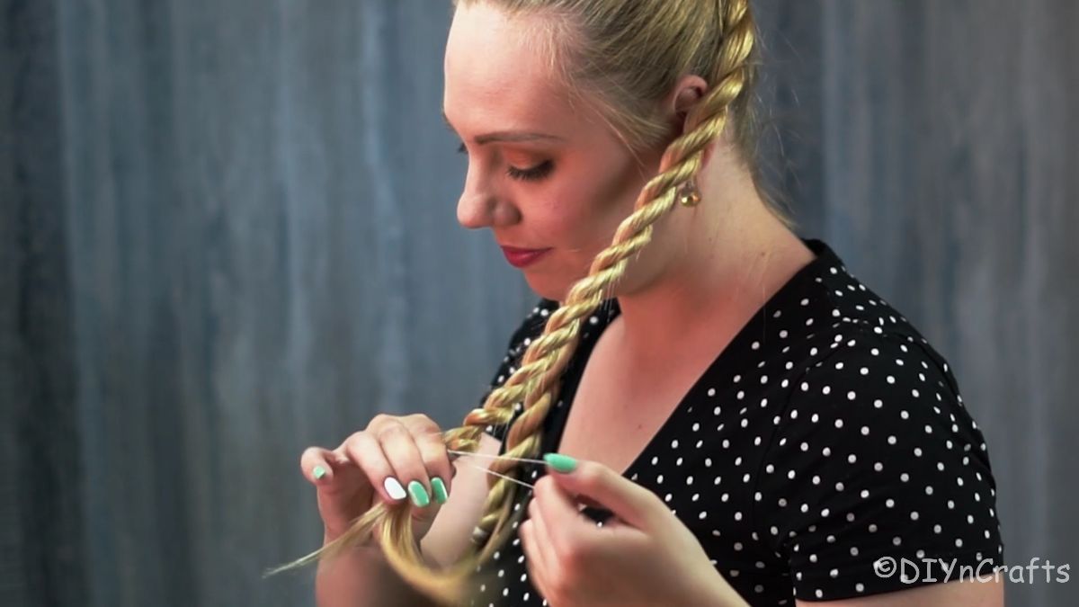 hand securing the end of a twisted braid