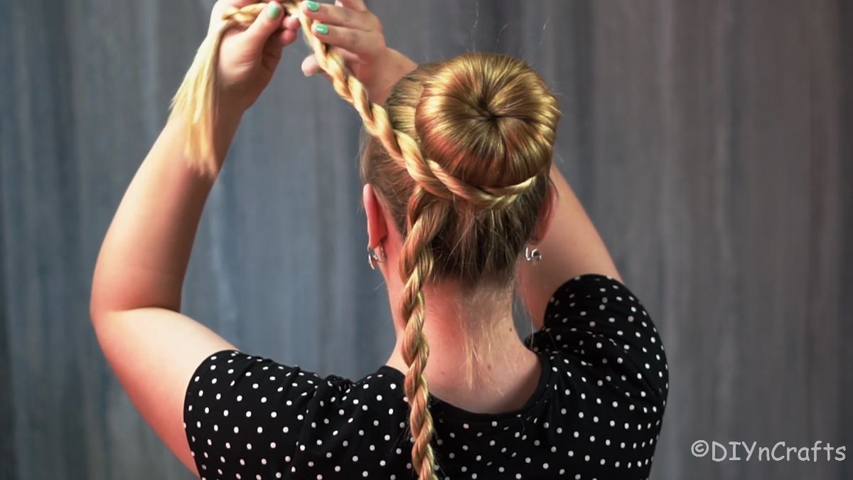 twisted braid being pulled up and wrapped around bun