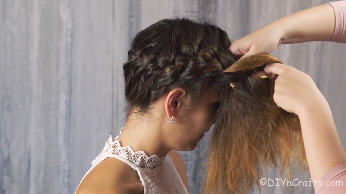 crown french braid being tightly braided against side of brunettes head