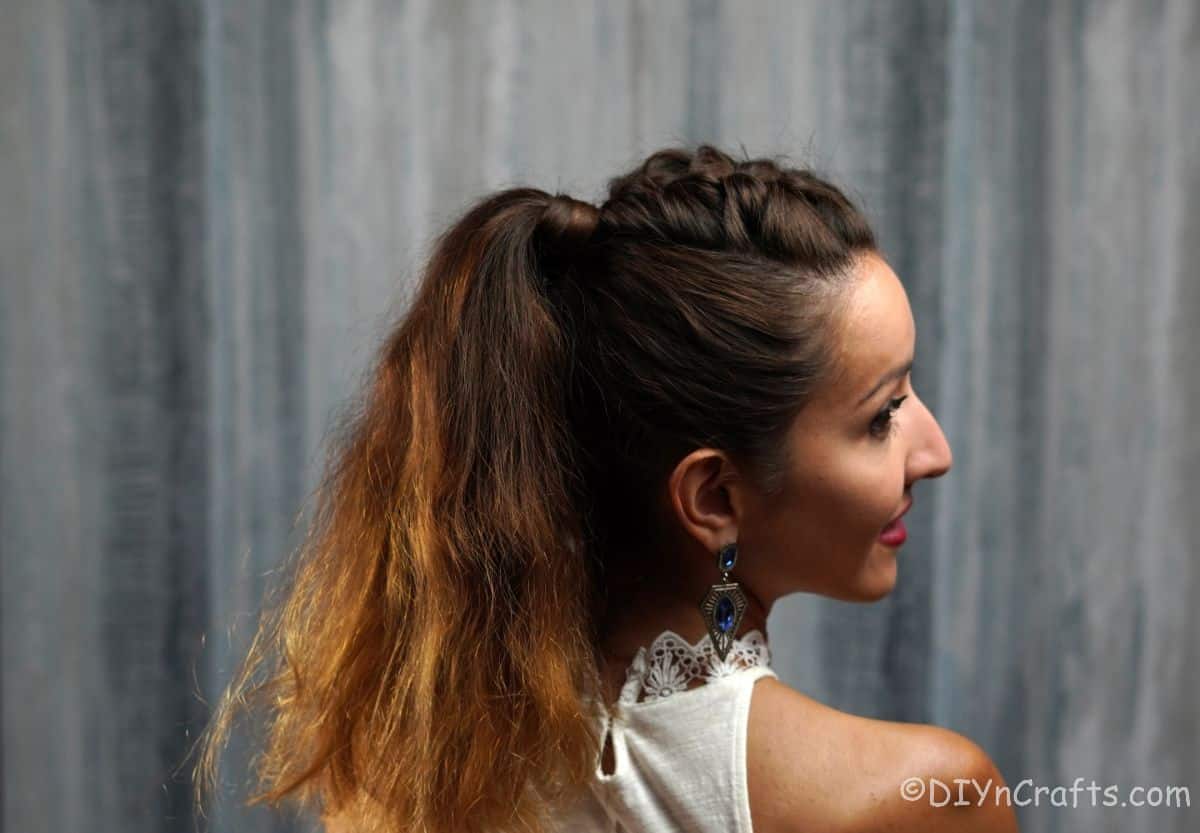 woman looking over her shoulder with brown hair in ponytail