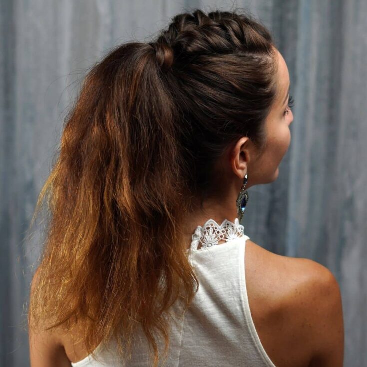 woman looking over her shoulder with brown hair in ponytail