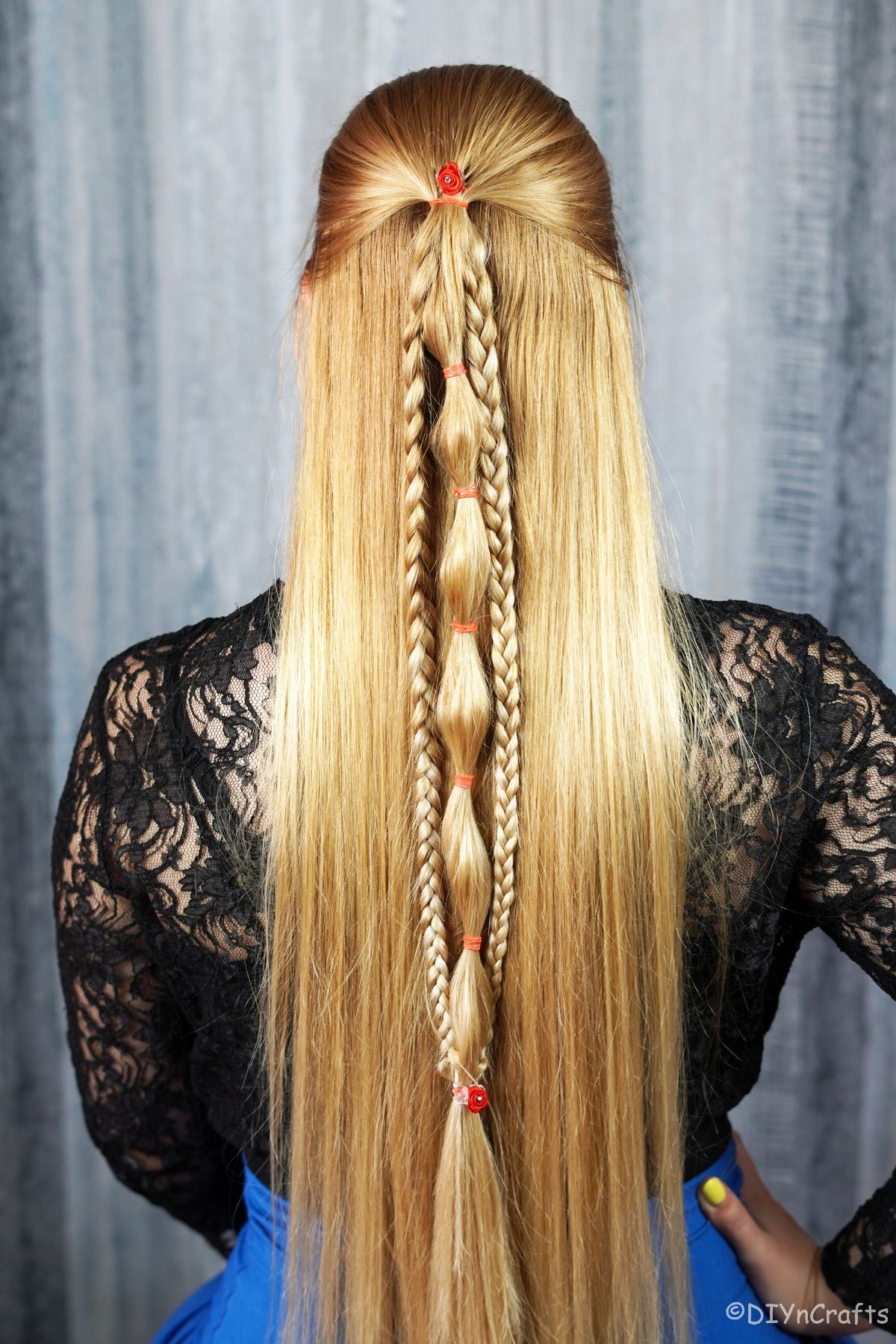 woman in black shirt and blue skirt with long blonde hair in braids