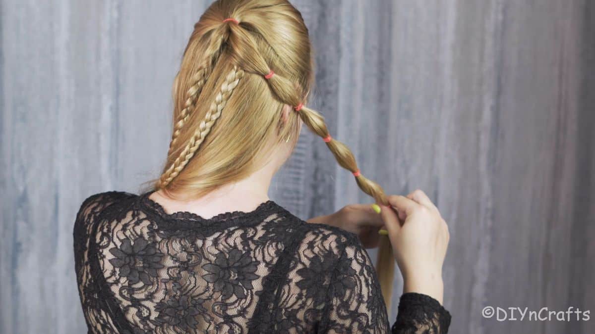 blonde woman creating bubble braids in hair