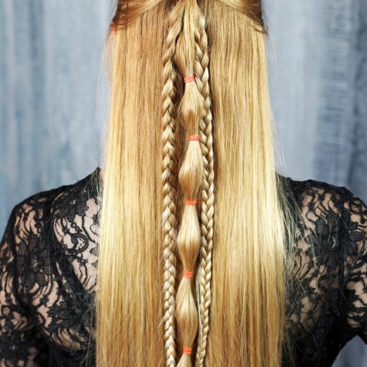 back of half up viking braids on blonde woman in black shirt