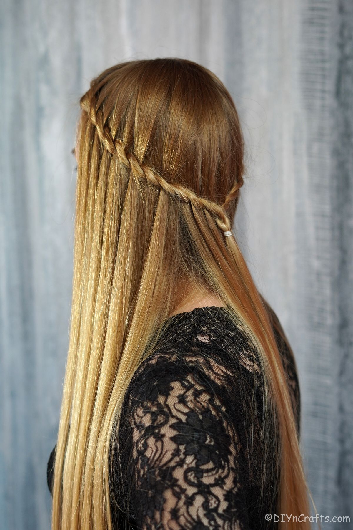 woman in black shirt with waterfall braid on back of hair