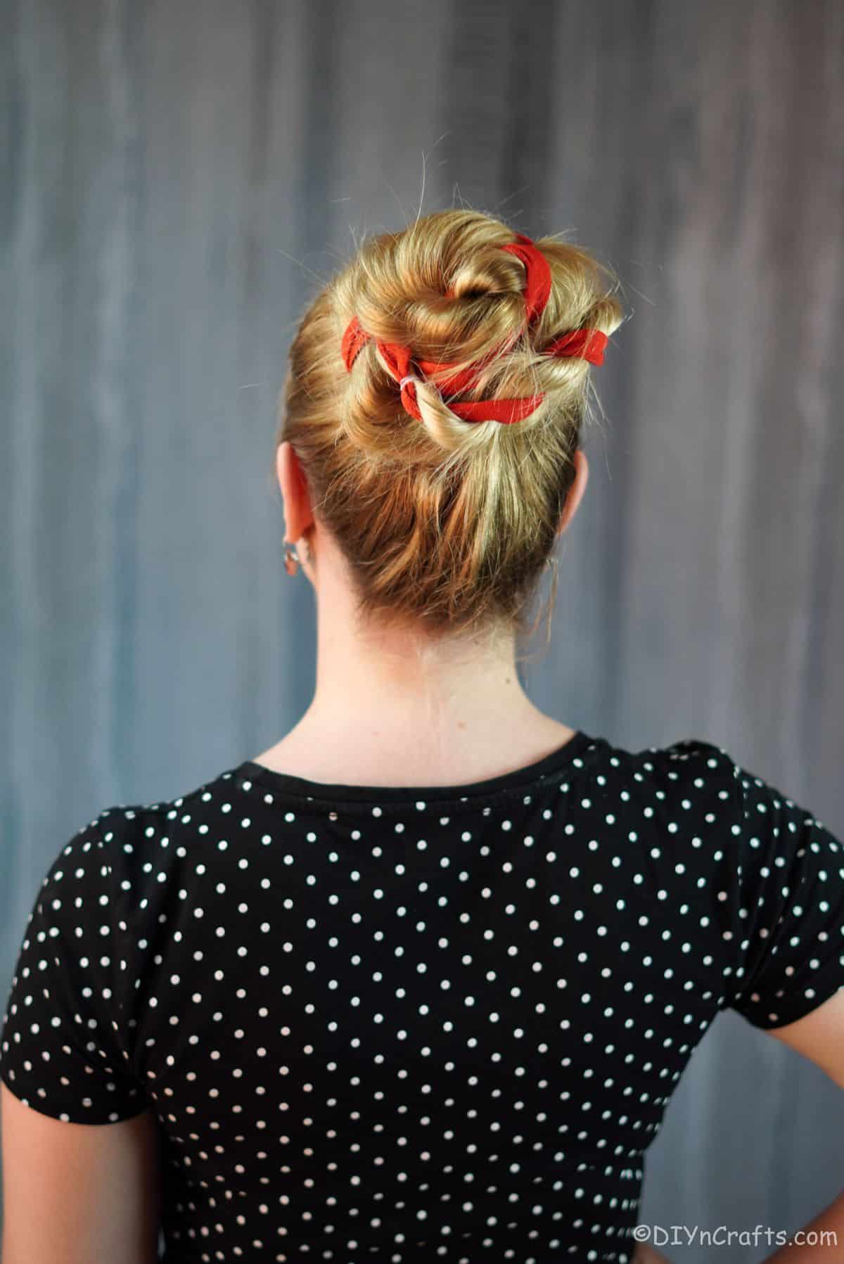 red ribbon twisted through braids on bun