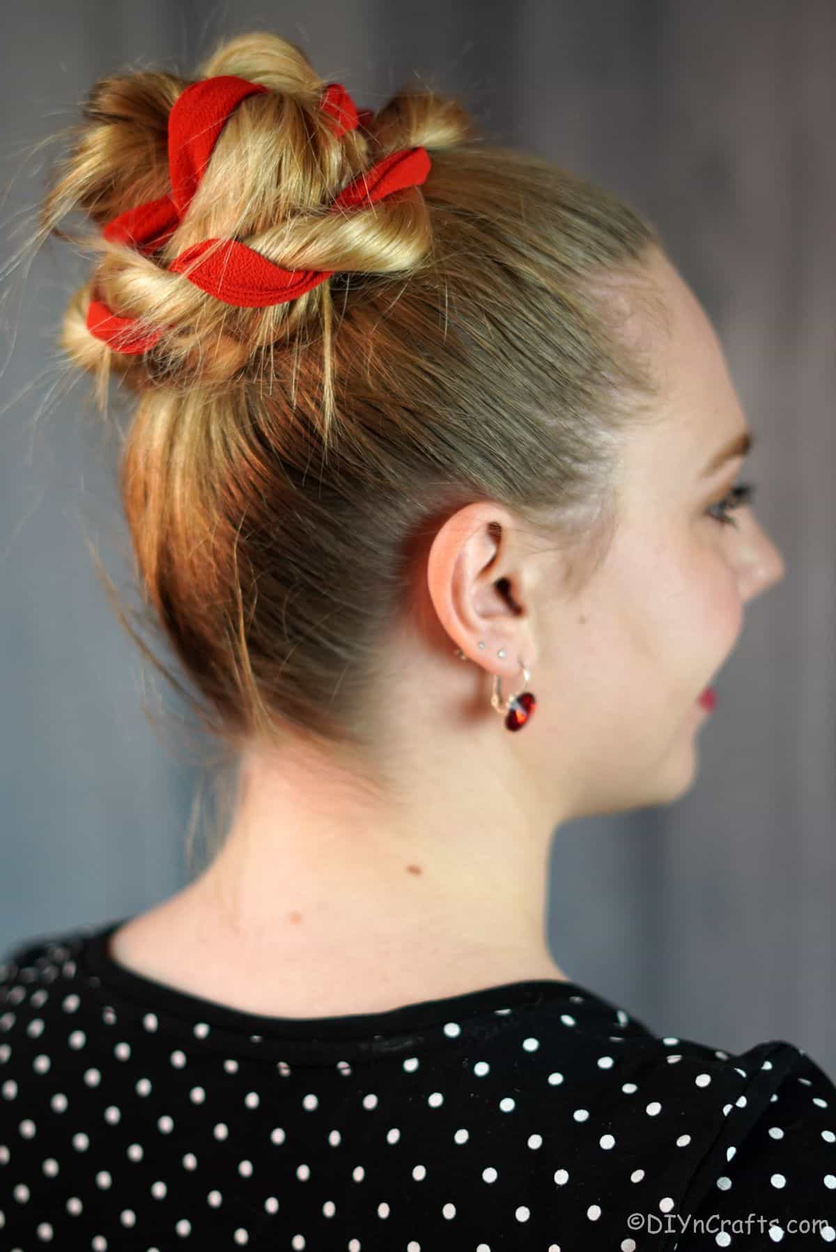 red ribbon in twisted high bun on blonde