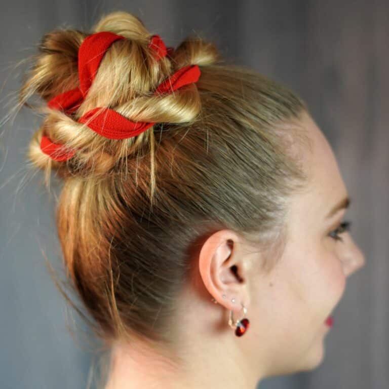 blonde woman in black and white shirt with red ribbon in hair