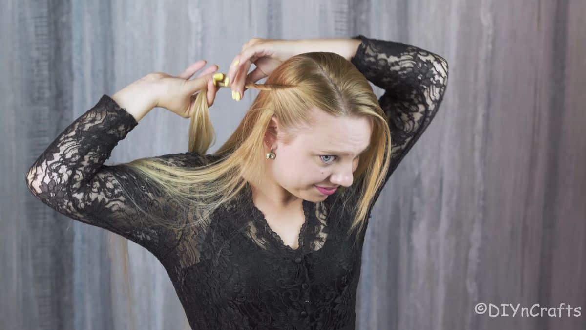 blonde woman twisting hair back from her face