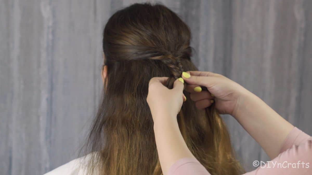 side pieces of hair being pulled into braid