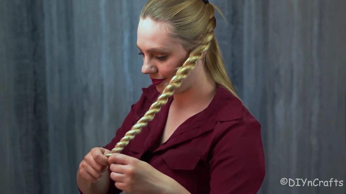hair tie being added to bottom of rope twist braid